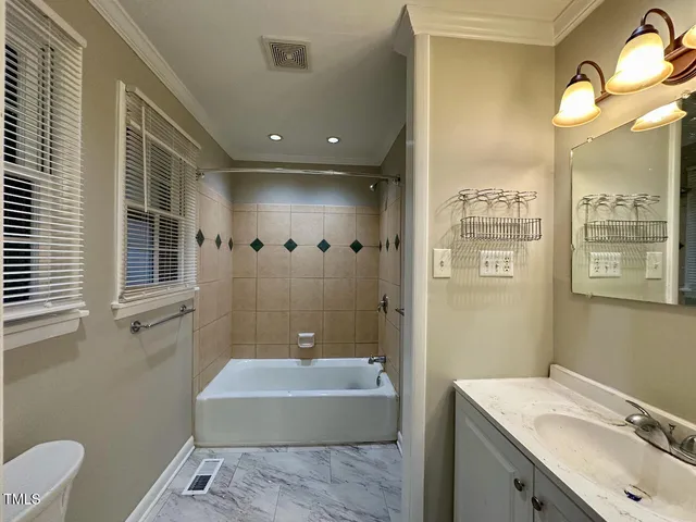 a bathroom with a granite countertop sink a toilet a mirror and bathtub