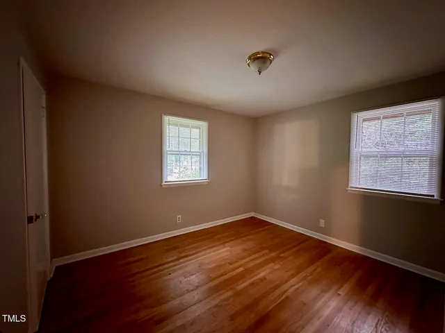 a view of a room that has wooden floor and windows in it