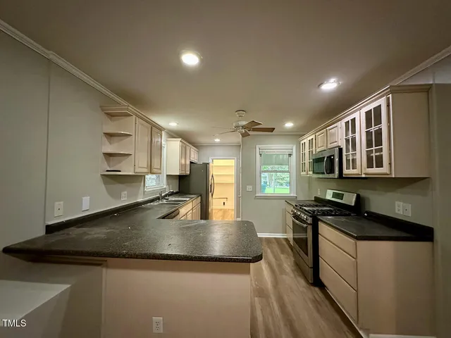 a kitchen with kitchen island a sink stove and cabinets