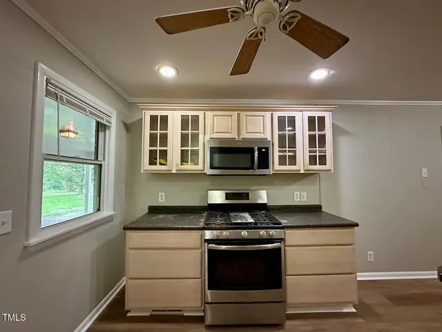 a kitchen with stainless steel appliances kitchen island a stove and a microwave