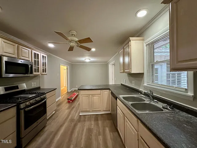 a kitchen with stainless steel appliances granite countertop a sink stove and refrigerator