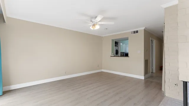 a view of a room with wooden floor and a ceiling fan