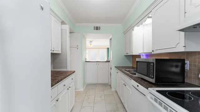 a kitchen with granite countertop white cabinets and stainless steel appliances