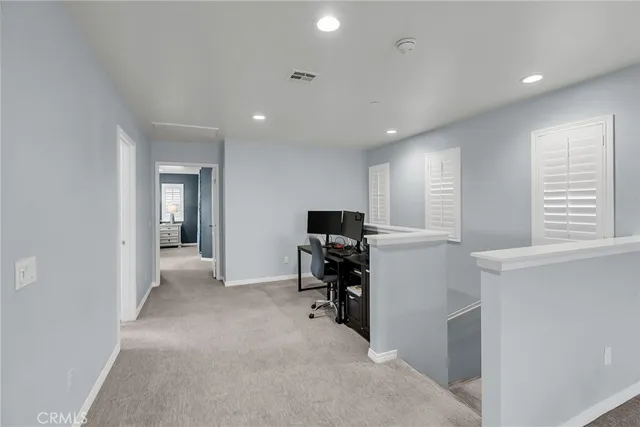 a view of a workspace with furniture and a window