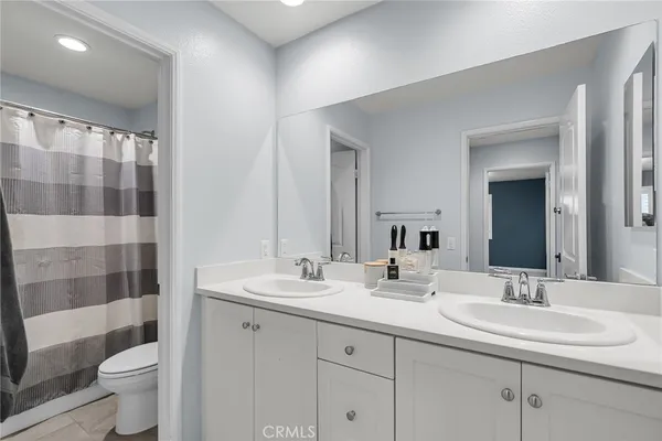 a bathroom with a double vanity sink toilet and shower