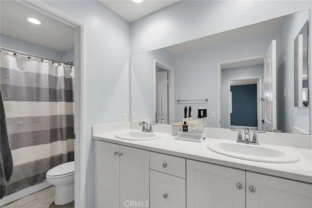 a bathroom with a double vanity sink toilet and shower