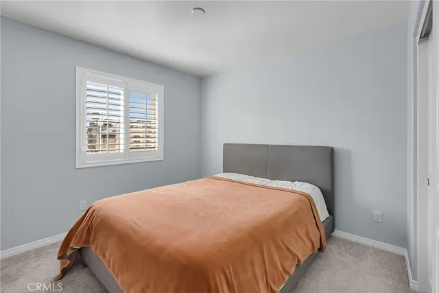 a large bed sitting in a bedroom next to a window