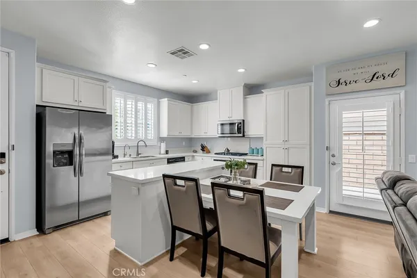 a kitchen that has a lot of cabinets a sink and appliances in it