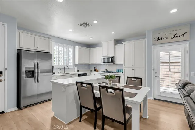 a kitchen that has a lot of cabinets a sink and appliances in it