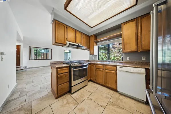 a kitchen with stainless steel appliances granite countertop a stove a sink and a refrigerator