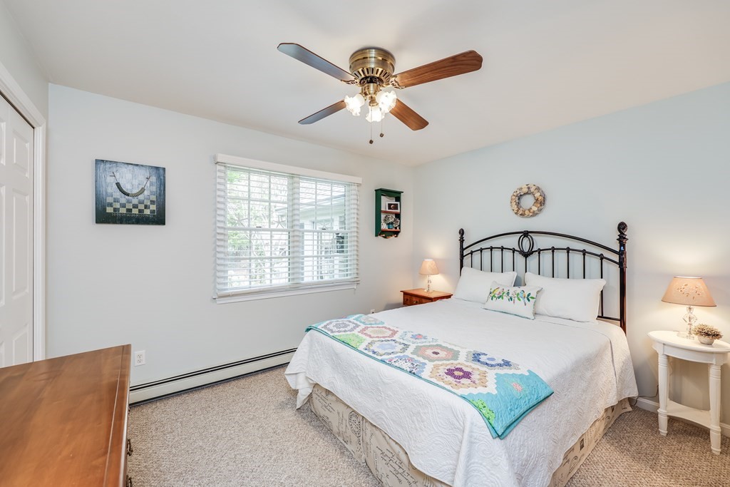 20 Courtney Road Harwich, MA 02645 - Photo 30 of 42 a bedroom with a bed and a chandelier