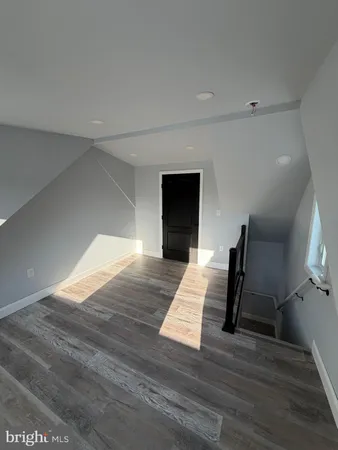 a view of a livingroom with wooden floor and staircase