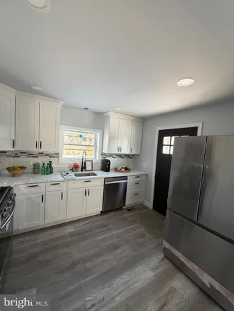 a kitchen with granite countertop white cabinets and white appliances