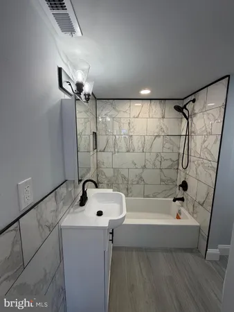 a bathroom with a bathtub a sink and a shower