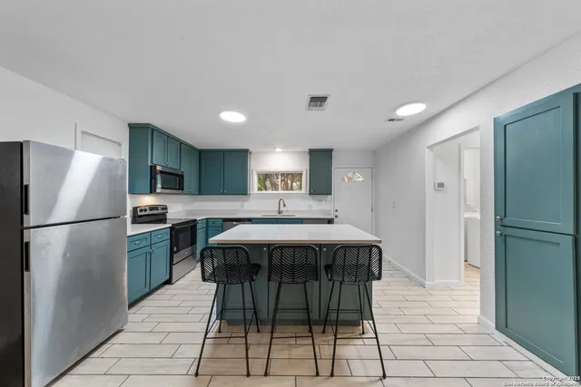 a kitchen with stainless steel appliances a refrigerator and a stove top oven