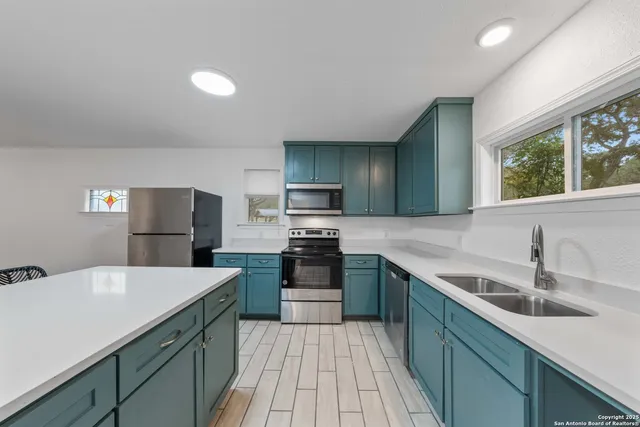 a kitchen with a sink stove and refrigerator