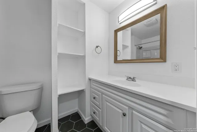 a bathroom with a toilet sink and mirror