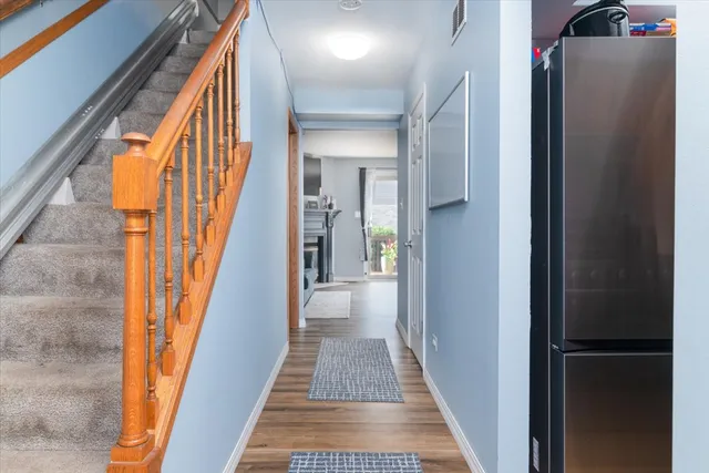 a view of a hallway with wooden floor and stairs