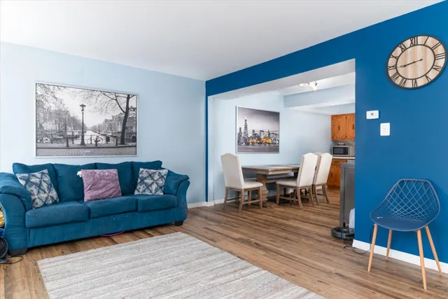 a living room with furniture wooden floor and dining table