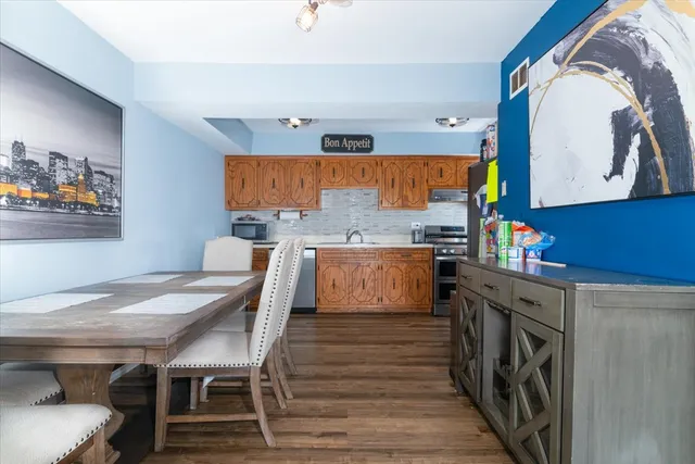 a view of a dining room with furniture a rug and wooden floor
