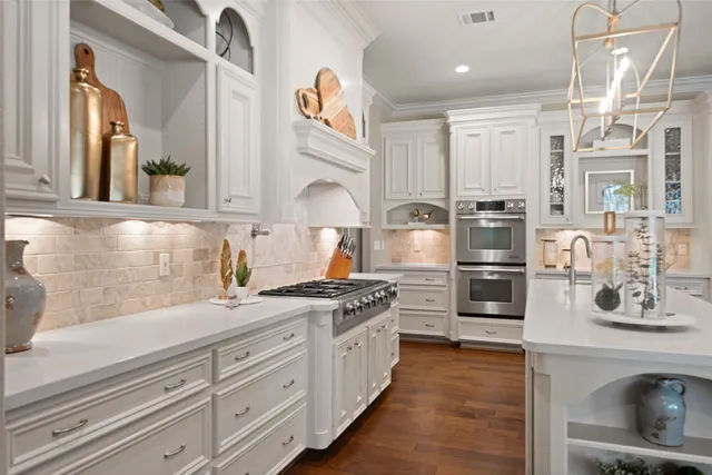 a kitchen with stainless steel appliances granite countertop a stove a sink and a refrigerator