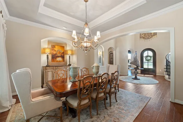 a dining room with furniture a chandelier and wooden floor