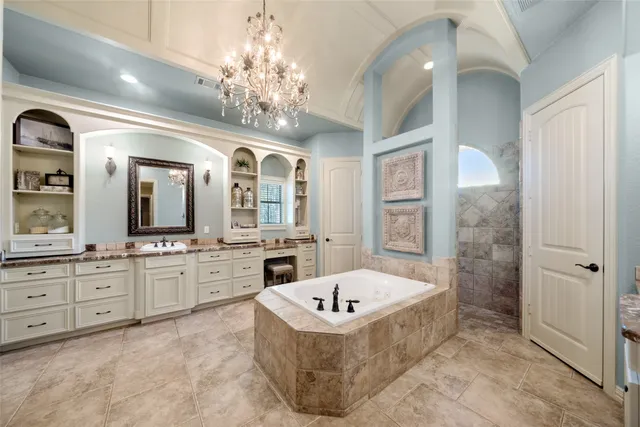 a large spacious bathroom with a granite countertop tub a double vanity sink a vanity a window and a mirror