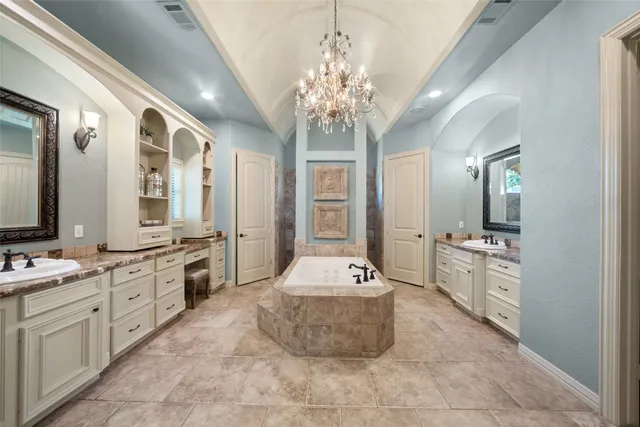 a large spacious bathroom with a tub sink and mirror