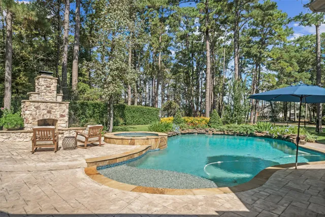 a view of a swimming pool with lawn chairs under an umbrella