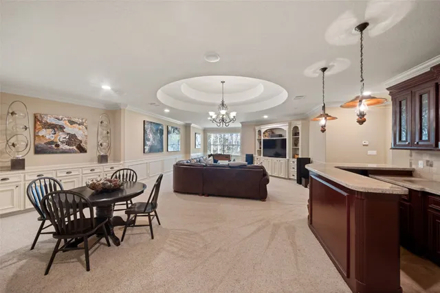 a living room with furniture a dining table and a chandelier
