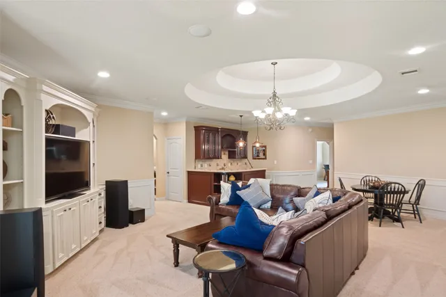 a living room with furniture a flat screen tv and kitchen view