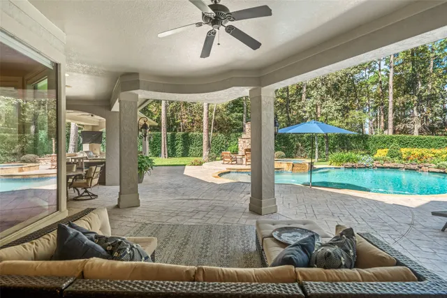a living room with couch floor to ceiling windows and a flat screen tv