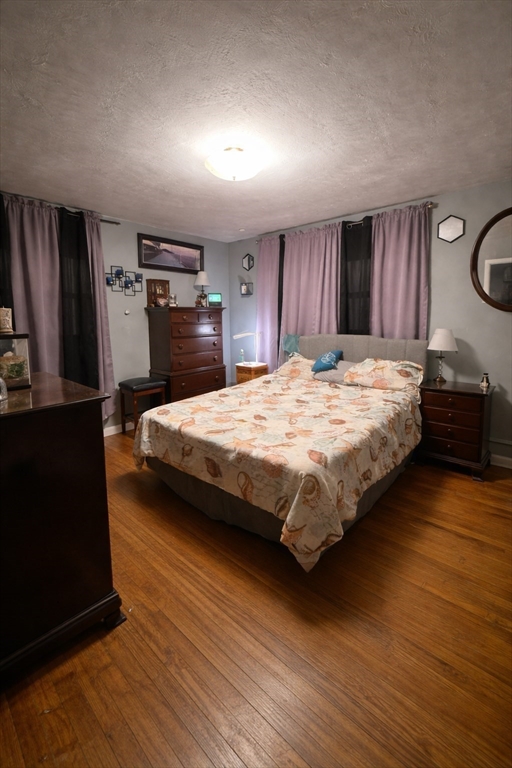 389 West Main Street Dudley, MA 01571 - Photo 12 of 19 a bedroom with a bed and wooden floor