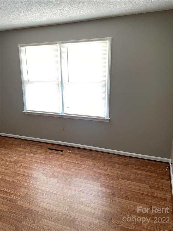 2306 Startown Road Lincolnton, NC 28092 - Photo 3 of 6 an empty room with wooden floor and windows