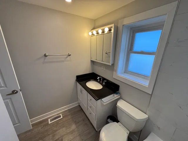 a bathroom with a toilet sink and mirror