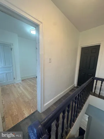 a view of a hallway with wooden floor and stairs