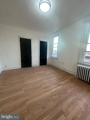an empty room with windows and closet