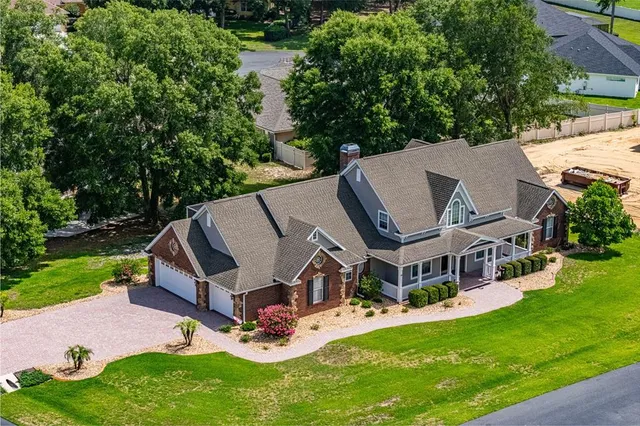 a view of house with a bench and a large tree