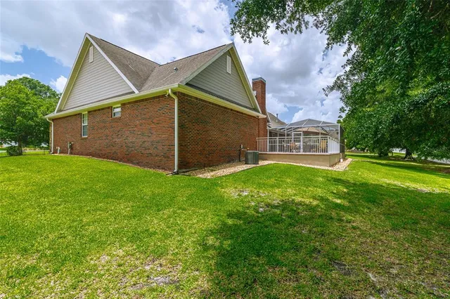 a dining room with wooden floor a chandelier a wooden table and chairs