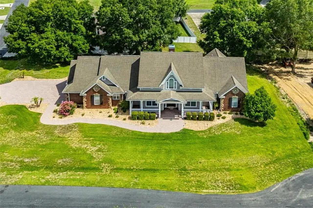 an aerial view of a house with garden space and a swimming pool