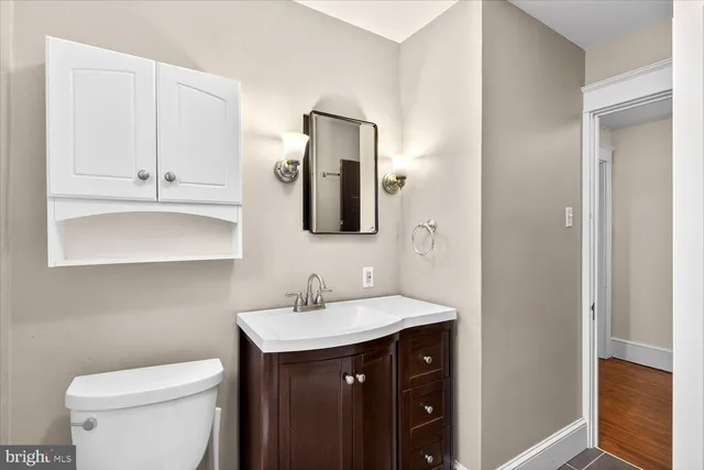 a bathroom with a toilet sink and mirror