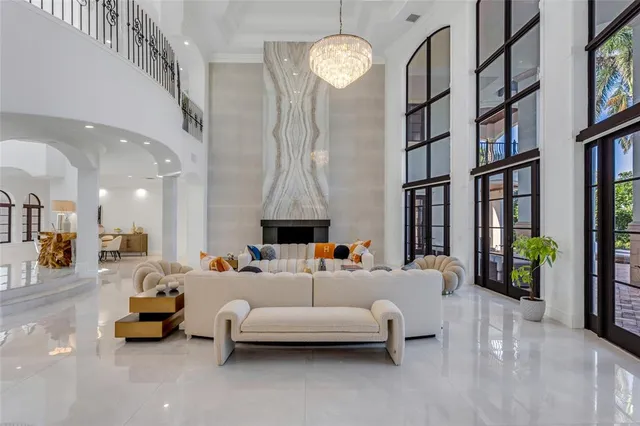 a living room with furniture a chandelier and a flat screen tv