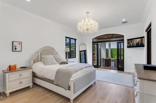 a view of a garden with a table and chairs under an umbrella with palm trees