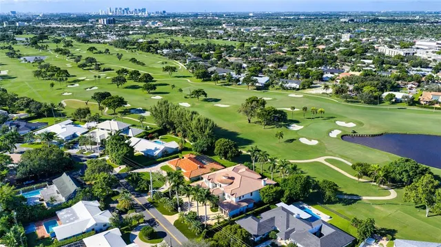an aerial view of residential houses with outdoor space and trees
