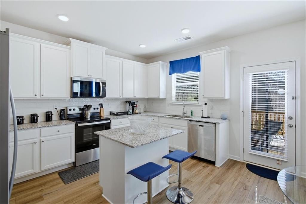 3980 Riverchess Drive Southwest Atlanta, GA 30331 - Photo 11 of 46 a kitchen with granite countertop white cabinets and white appliances