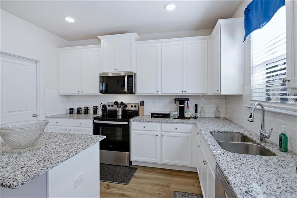 3980 Riverchess Drive Southwest Atlanta, GA 30331 - Photo 12 of 46 a kitchen with granite countertop a sink a stove and cabinets