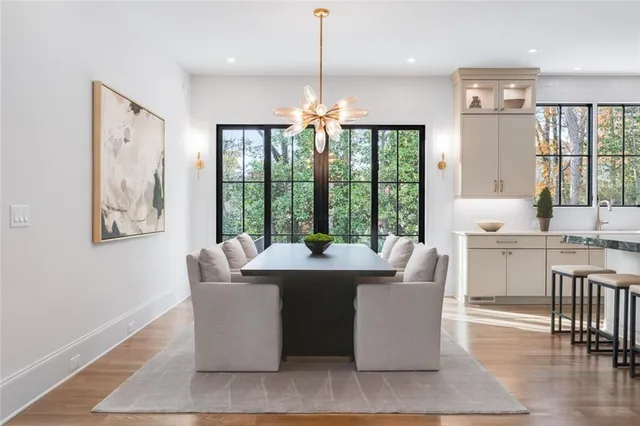 a dining room with furniture a chandelier and wooden floor