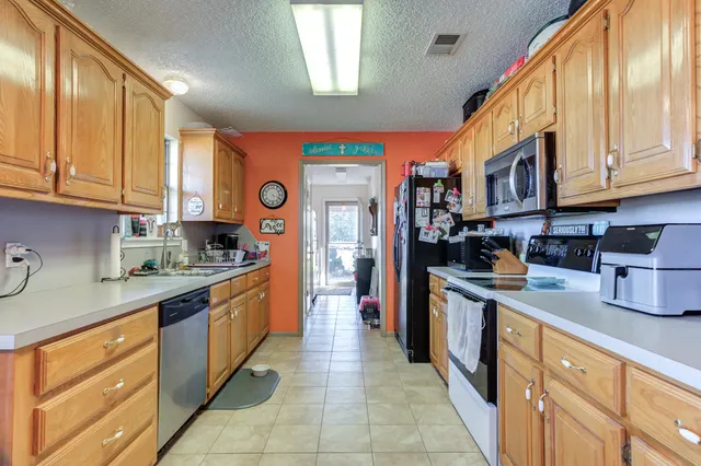 a large kitchen with stainless steel appliances granite countertop a stove a sink dishwasher and a refrigerator