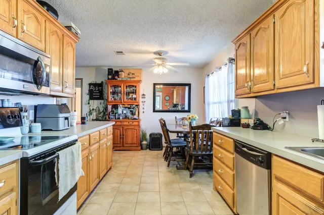 a kitchen with stainless steel appliances granite countertop sink stove top oven and cabinets