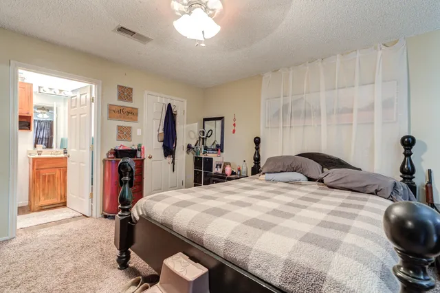 a bedroom with a bed and a large mirror with a potted plant